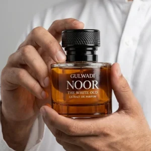 Noor White Oud perfume by Gulwadi held in hands - amber bottle with black cap